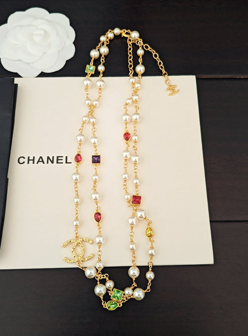 Gold-tone charm necklace set with pearl beads, dangling drops, and colorful stones