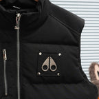 Black sleeveless puffer vest with chest logo patch and snap-front pockets