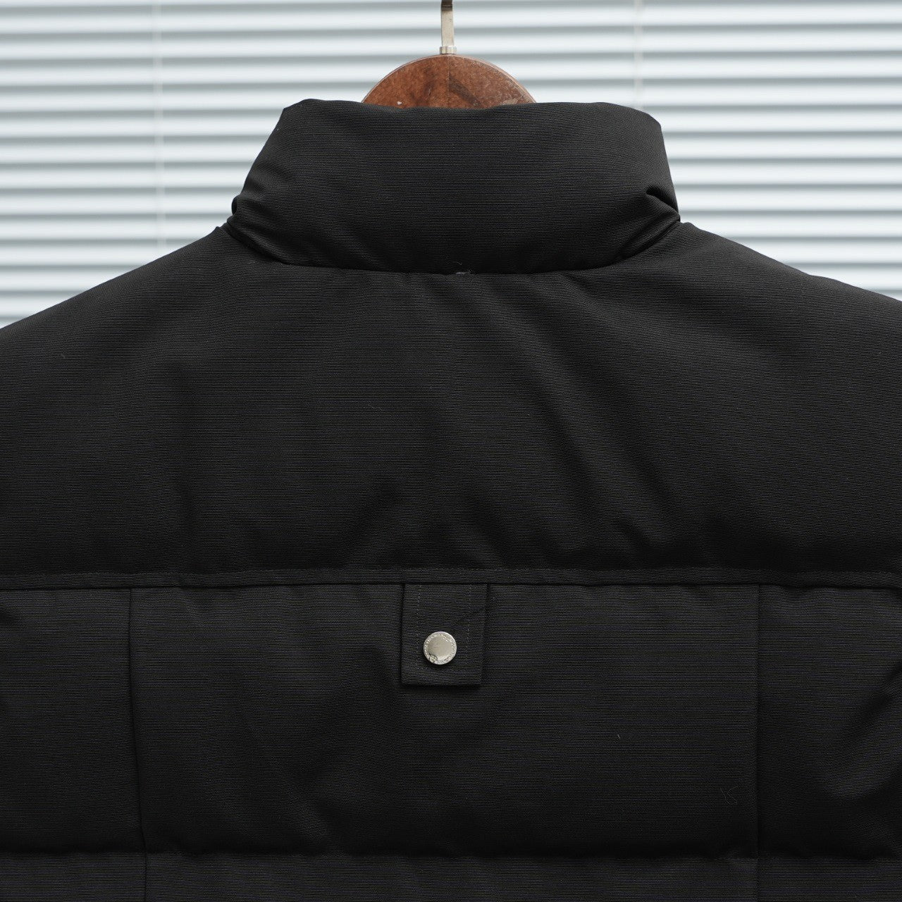 Black sleeveless puffer vest back with stand collar and snap button