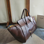 Brown leather tote bag with slouch shape, top handles, and zip pockets