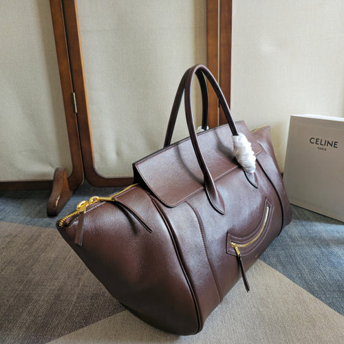 Brown leather tote bag with slouch shape, top handles, and zip pockets