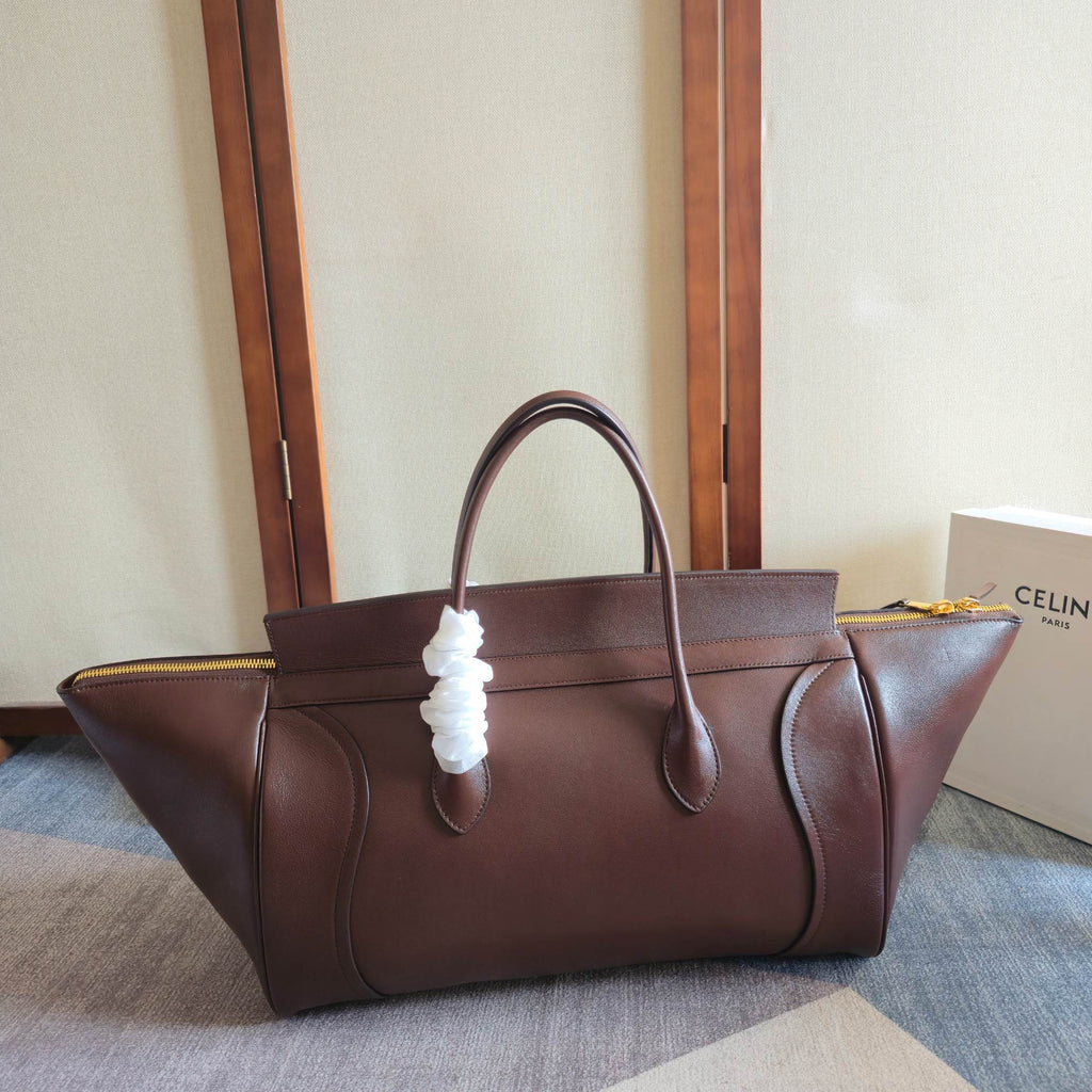 Brown leather tote bag with top handles and white cord charm