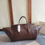 Brown leather tote bag with top handles and white cord charm
