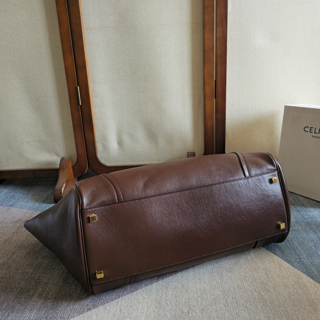 Brown leather tote bag with rolled handles and structured base
