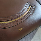 Brown leather tote bag with gold zipper track and small logo stamp