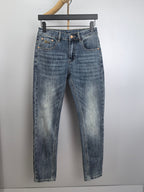 Blue denim pants with button closure, belt loops, and stitched front and back pockets