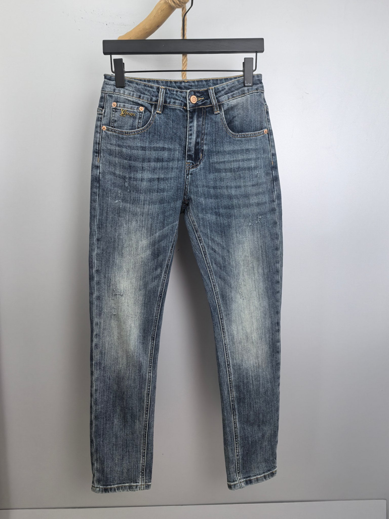 Blue denim pants with button closure, belt loops, and stitched front and back pockets