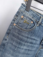 Blue denim pants front close-up with branded pocket patch and copper buttons