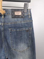 Blue denim pants back view with rectangular patch label and stitched back pocket