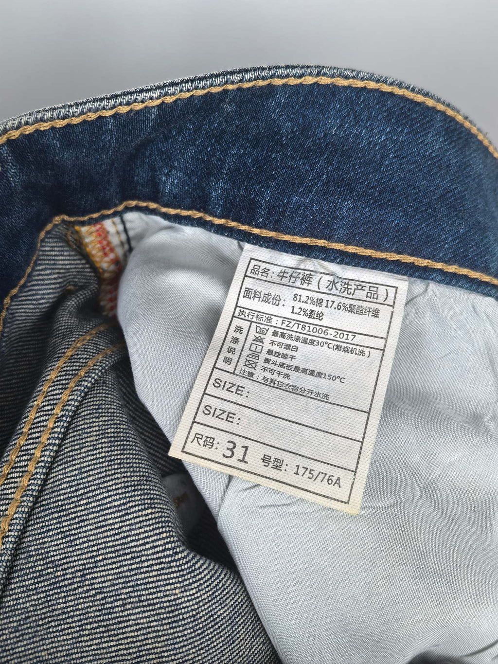 Denim jeans fabric with white care label inside waistband