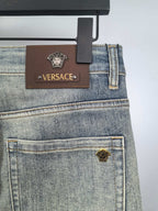 Light-blue denim jeans with leather Versace patch and logo rivets