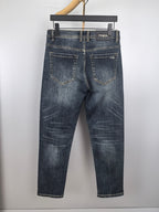 Dark blue denim pants with PRADA logo patch on waistband and front pockets.