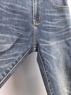 Dark blue denim pants with button fly seam and contrast yellow topstitching.