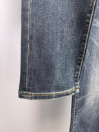 Dark blue denim pant hem with contrast yellow stitched cuff.
