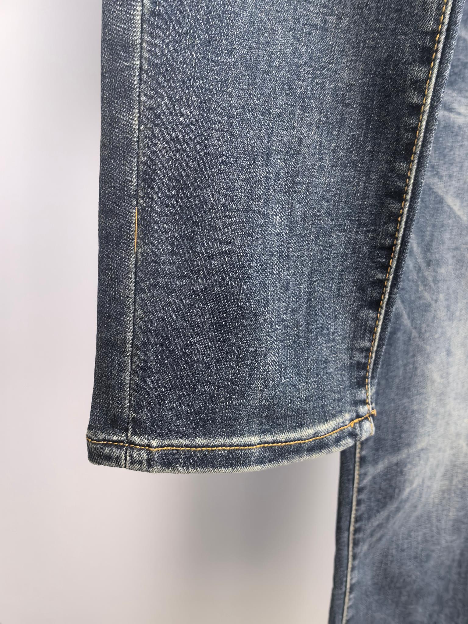 Dark blue denim pant hem with contrast yellow stitched cuff.