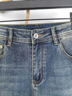 Blue denim pants waistband with metal button and stitched fly detail