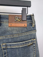 Burberry denim jeans with leather logo patch, front pockets, belt loops, dark blue wash