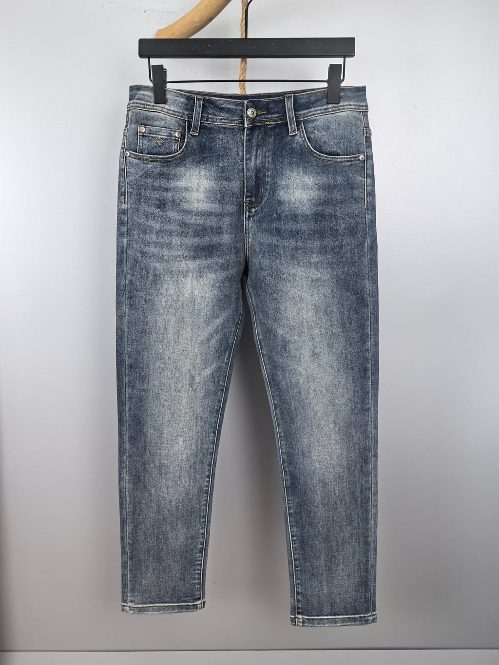 Blue denim pants with belt loops, button fly, and classic front pockets