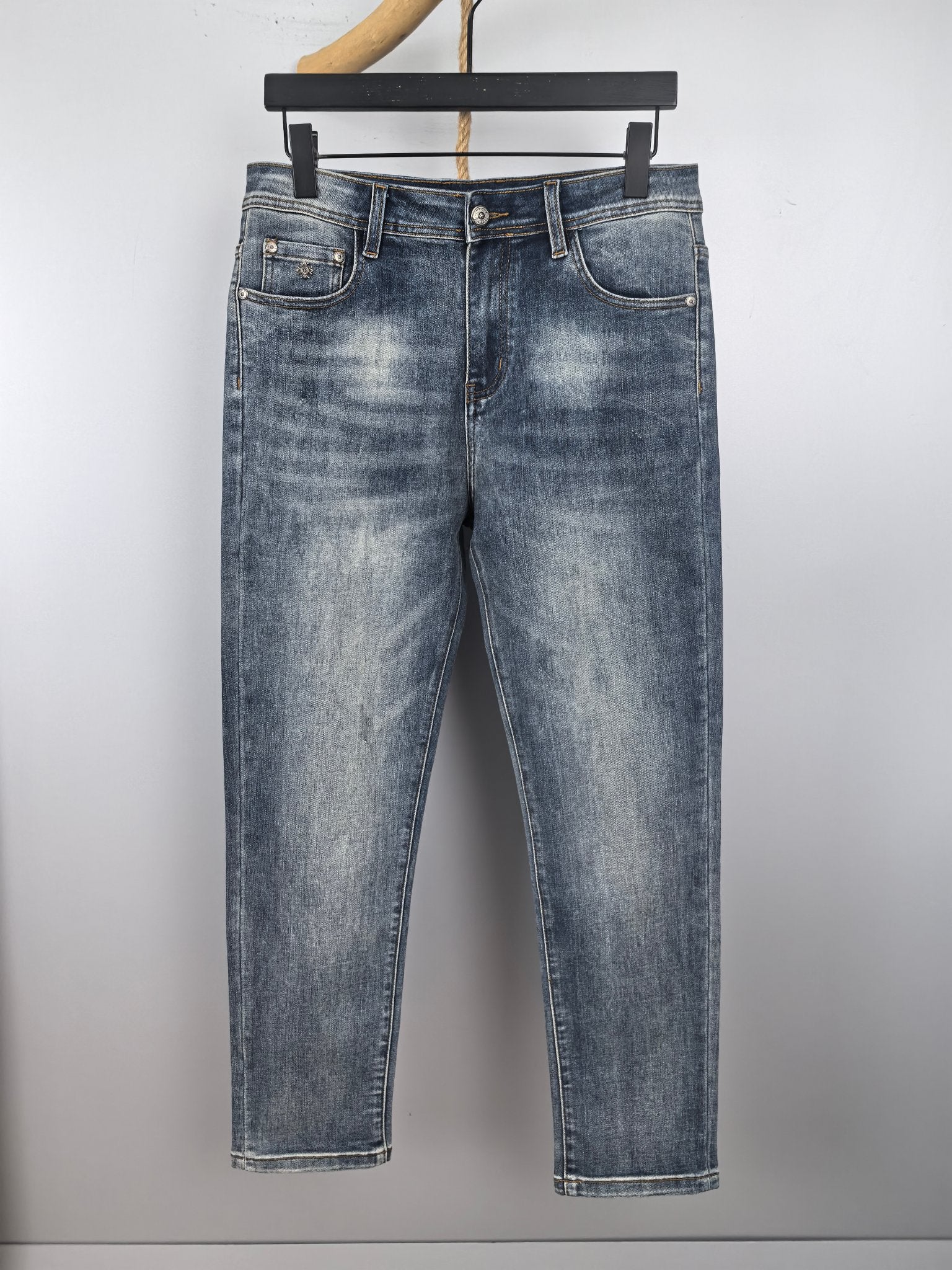 Blue denim pants with belt loops, button fly, and classic front pockets