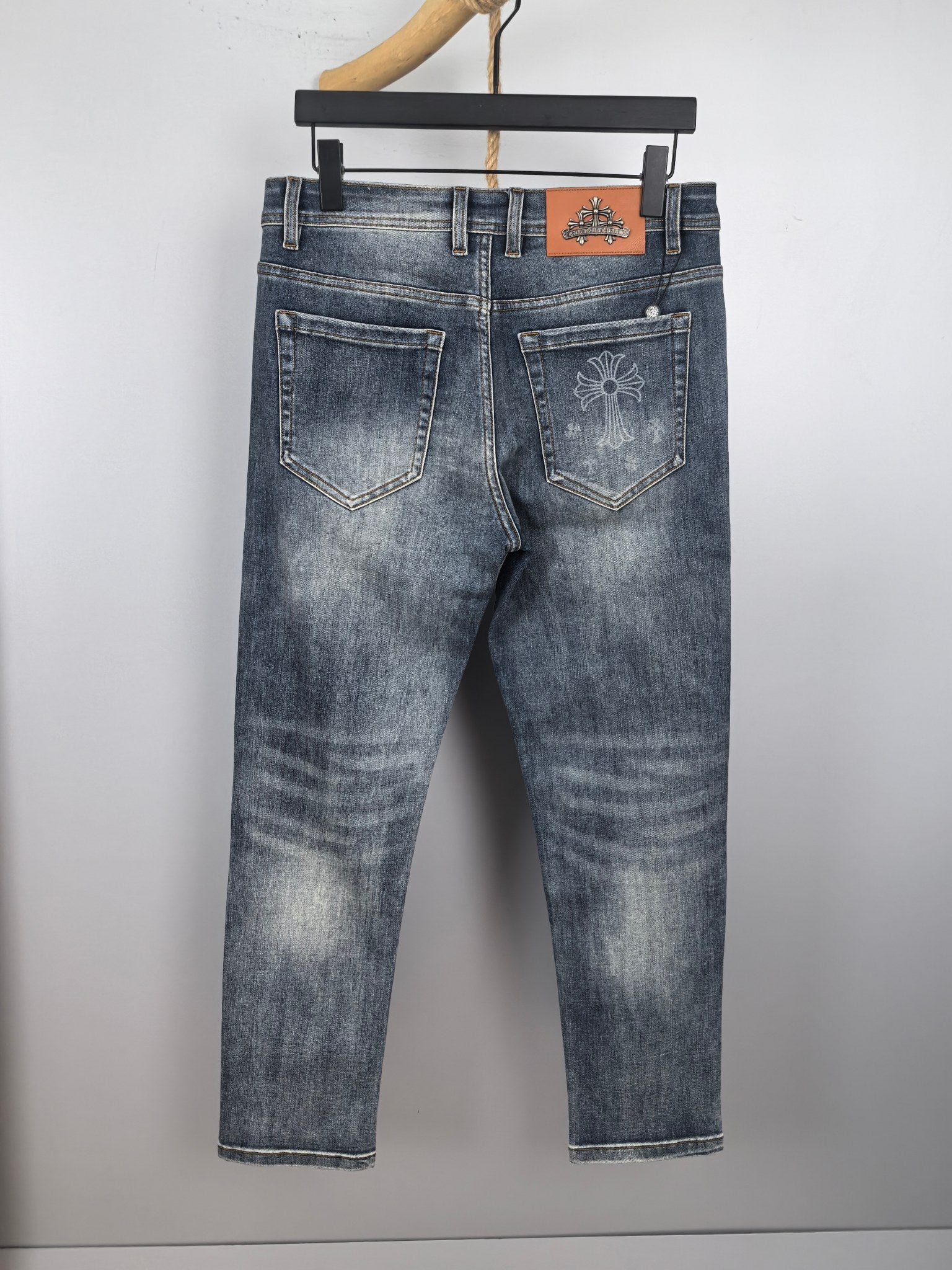 Blue denim pants with front and back pockets, stitched seams, and decorative patch