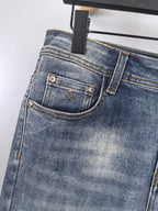Blue denim pants front pocket with gold-toned hardware and contrast stitching