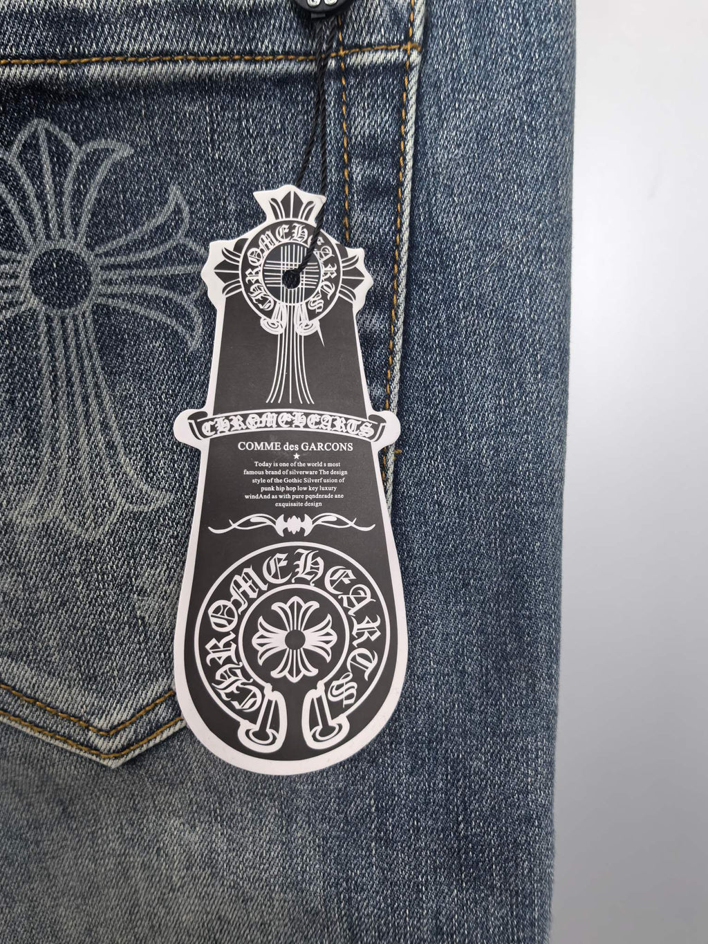 Blue denim pants pocket close-up with logo patch artwork