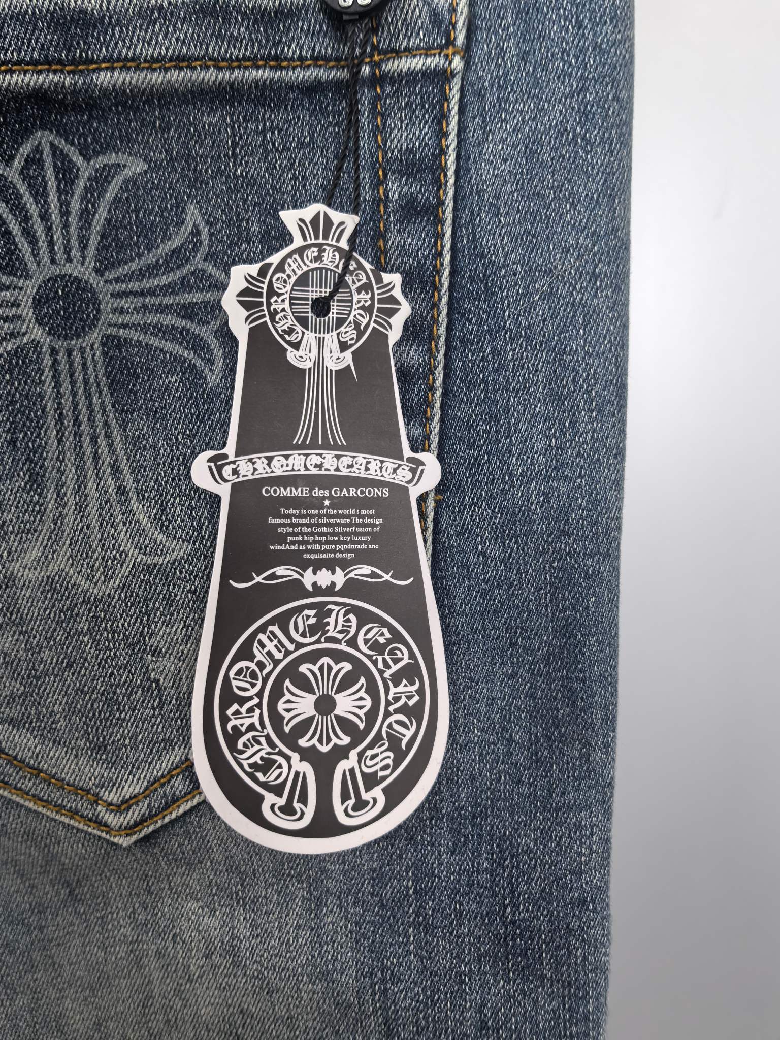 Blue denim pants pocket close-up with logo patch artwork
