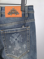 Blue denim pants back pocket with embossed cross design and orange brand patch