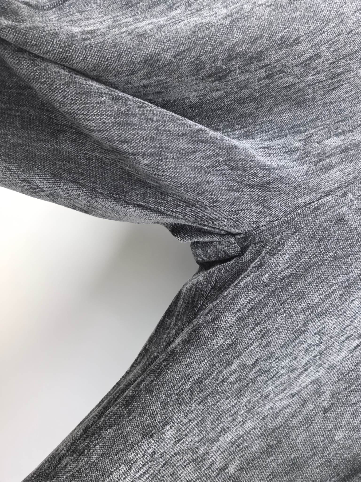 Charcoal trouser fabric with visible seam and inner waistband lining at the hem.