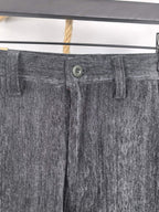 Charcoal trouser waistband with button closure, belt loops, and front fly detail.