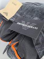 Charcoal trousers with orange inner trim and attached designer hang tags.