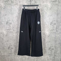 Balenciaga black wide-leg pants with elastic waistband, front logo patch and side stripes