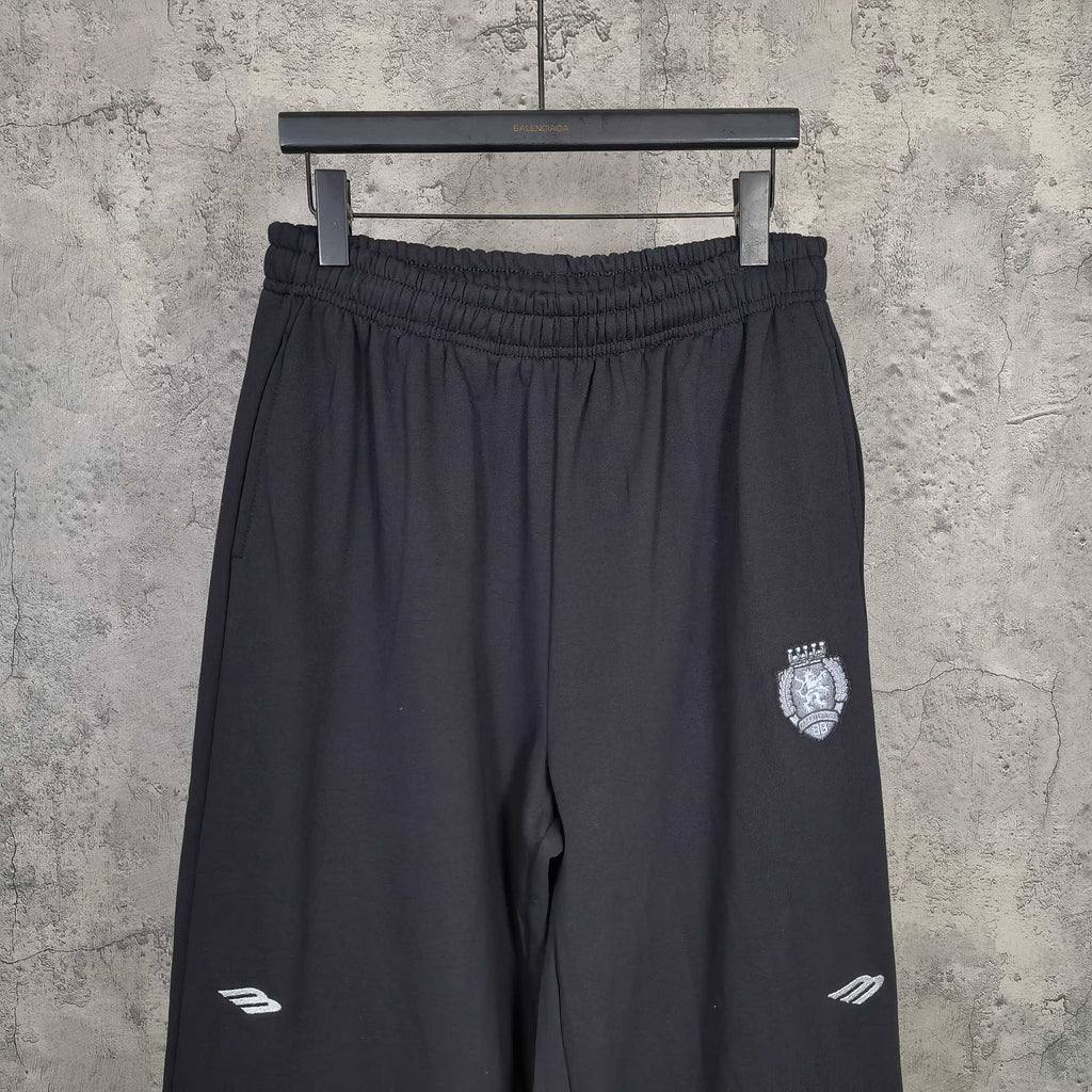 Balenciaga black pants with elastic waistband, crest patch on right leg, side logo