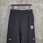 Balenciaga black pants with elastic waistband, crest patch on right leg, side logo