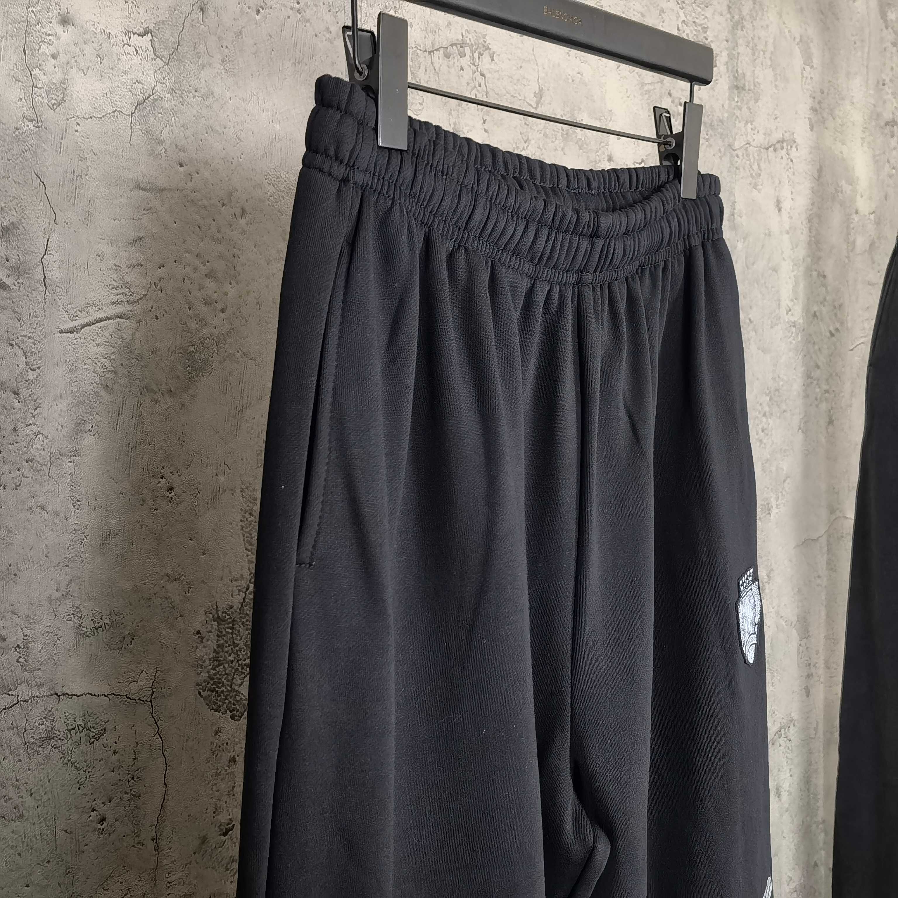 Balenciaga black pants on hanger, elastic waistband, crest patch on side leg