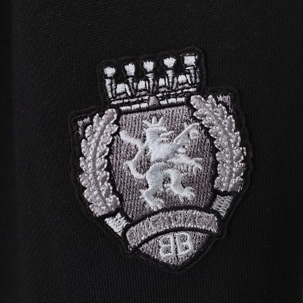 Balenciaga crest logo patch on black fabric, embroidered shield and text detail