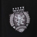 Balenciaga crest logo patch on black fabric, embroidered shield and text detail