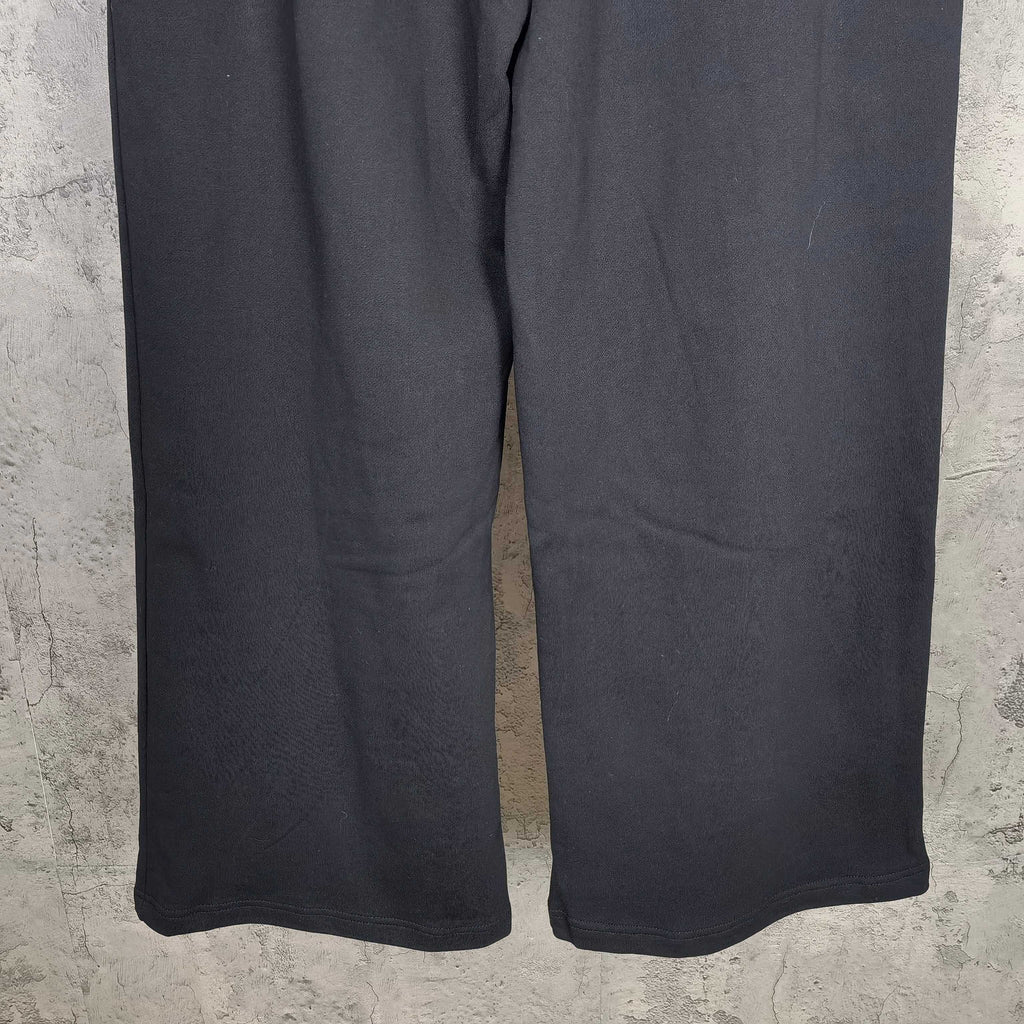 Dark wide-leg pants with elastic waist and visible hem stitching