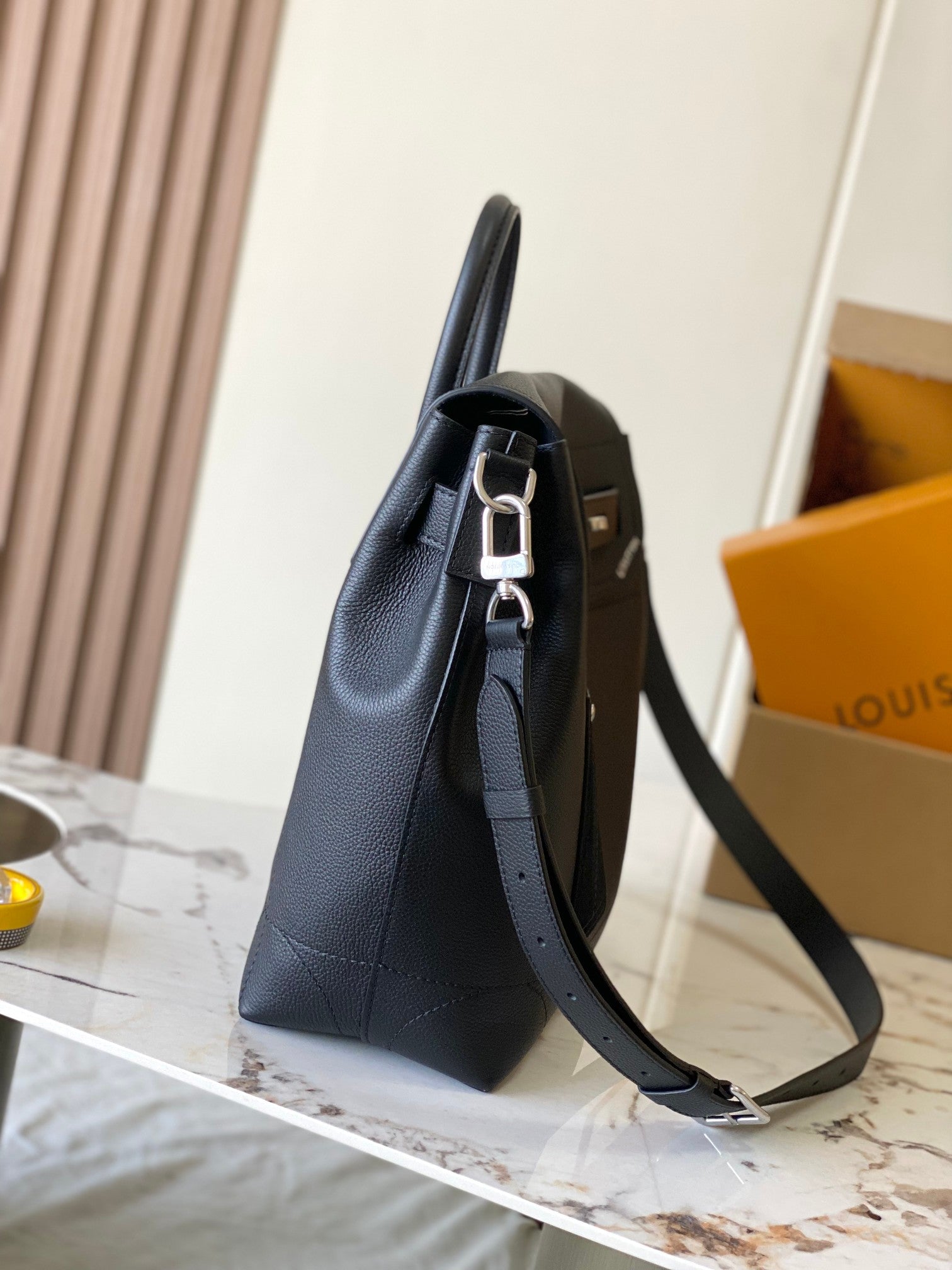 Louis Vuitton black leather handbag with side profile and adjustable shoulder strap