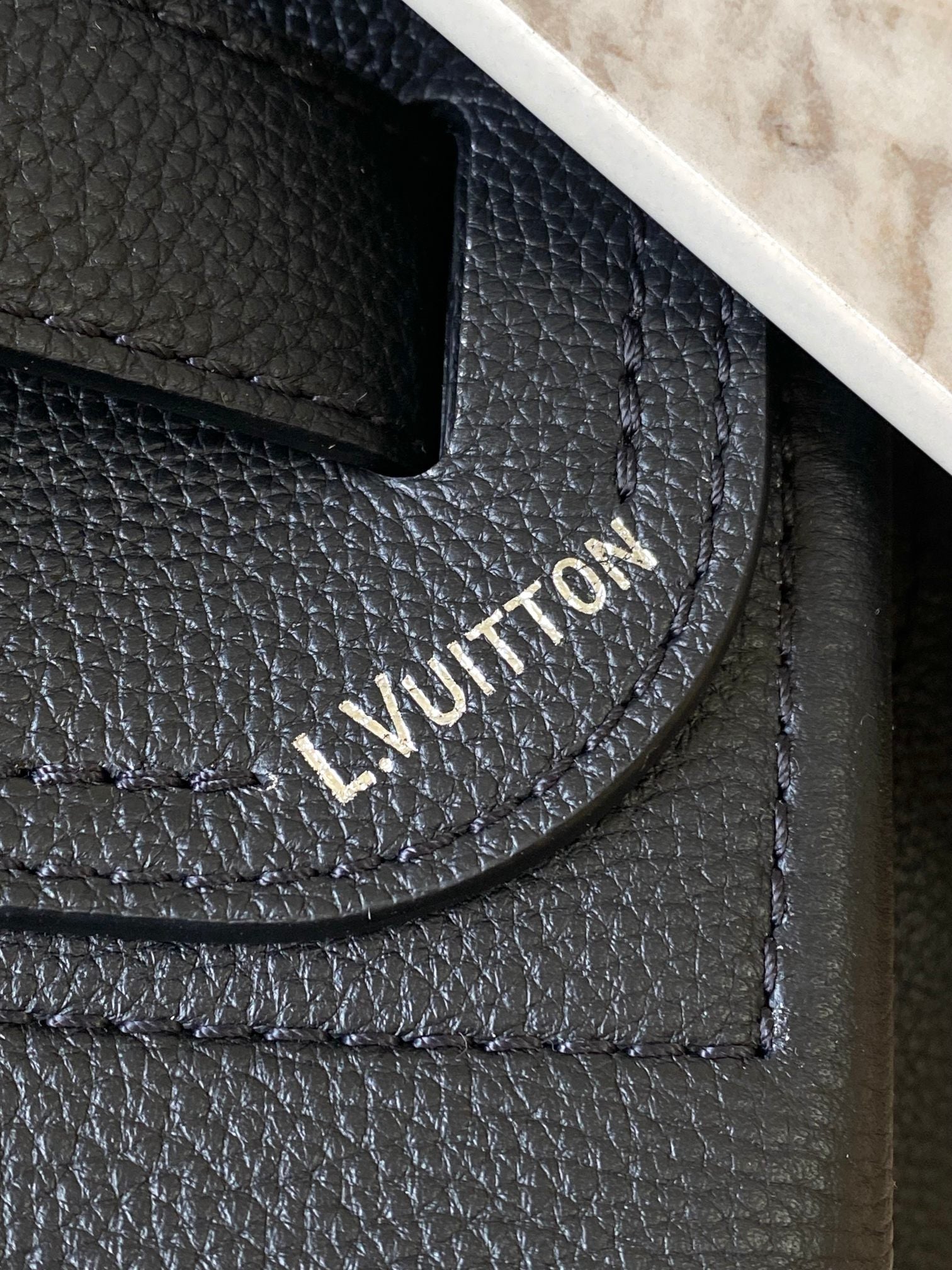 Louis Vuitton black leather handbag with embossed logo on textured grain