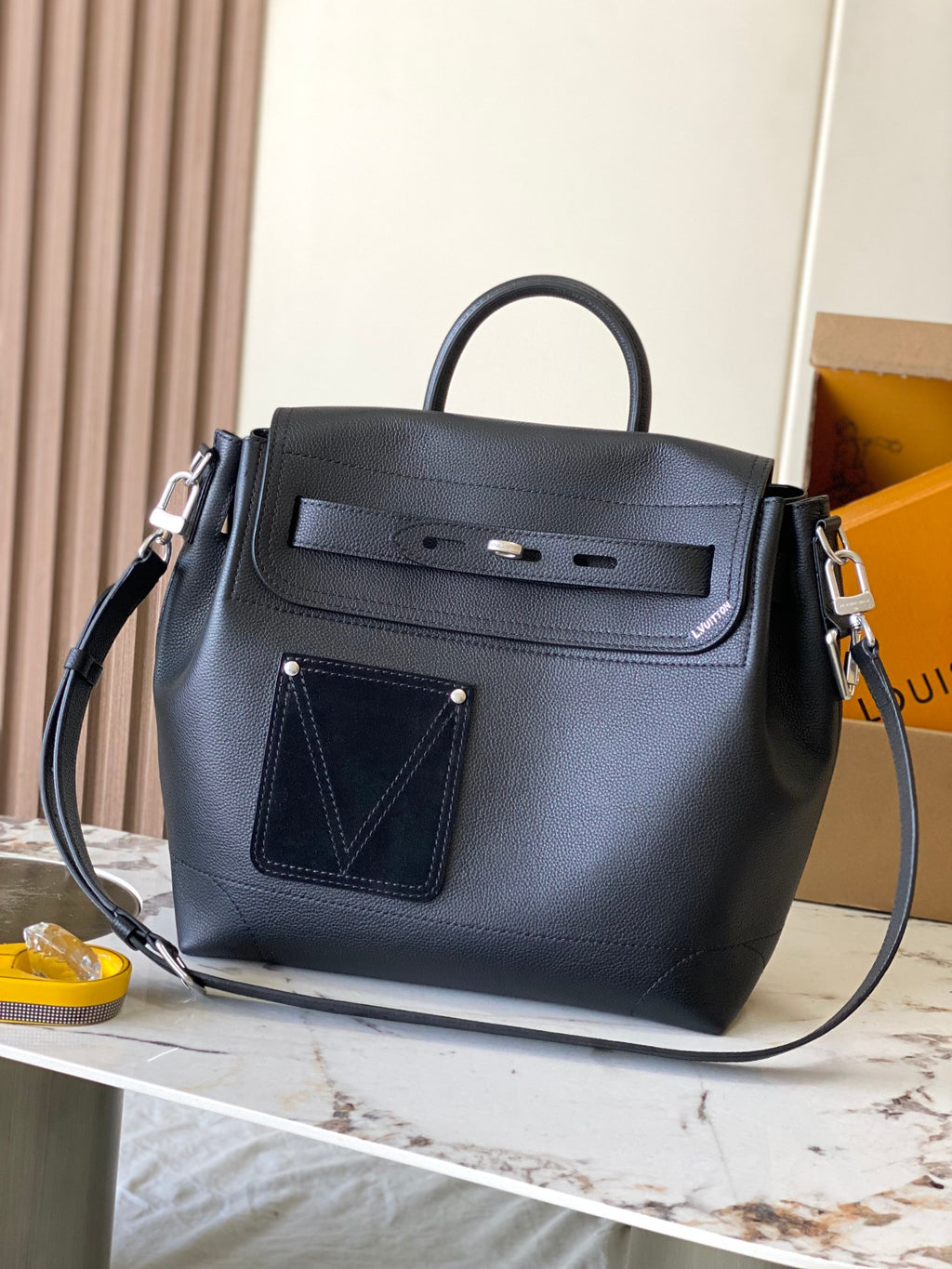 Louis Vuitton black leather handbag with top handles and front flap pocket