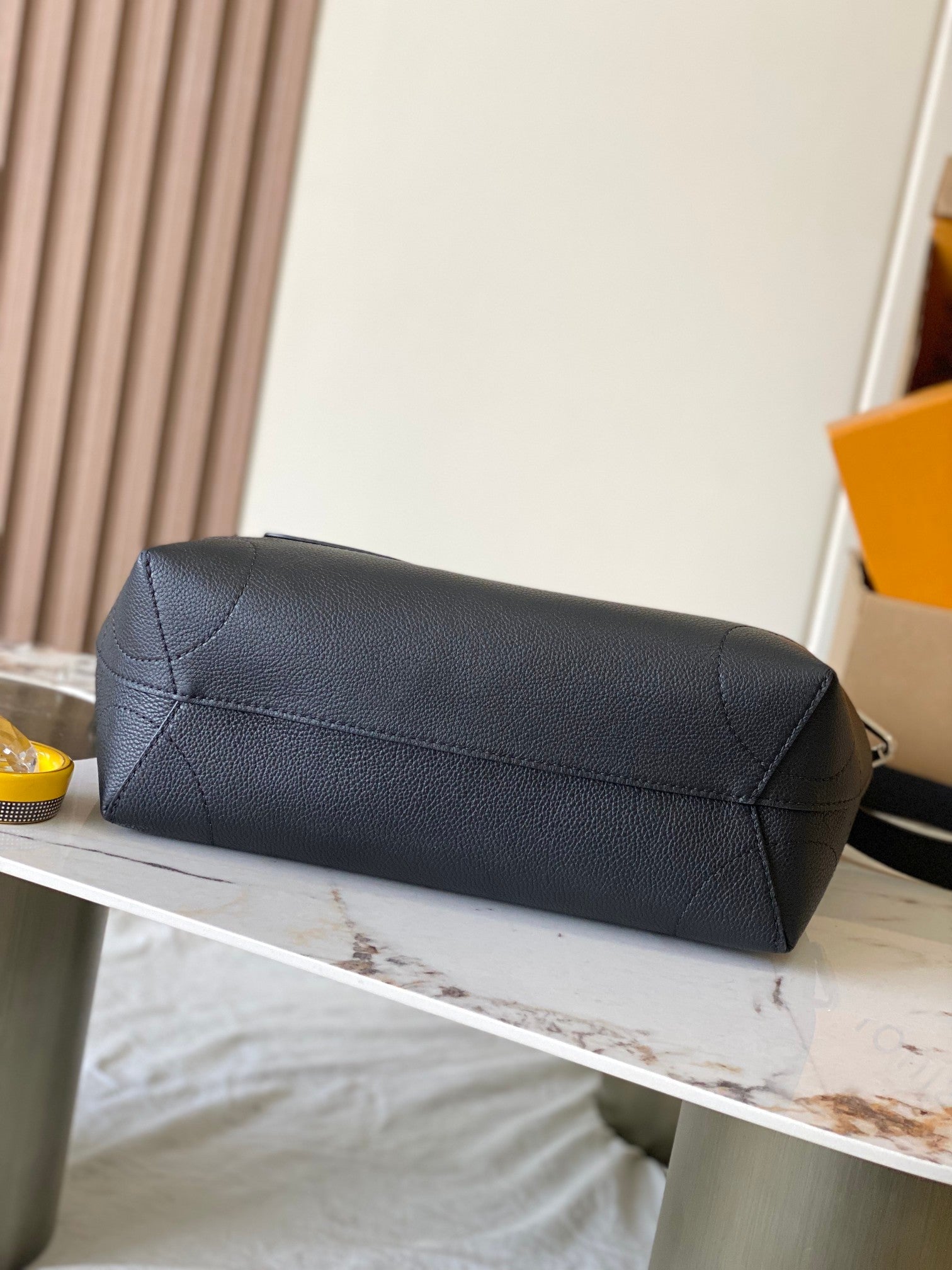 Louis Vuitton black leather handbag with rolled top flap and side stitching