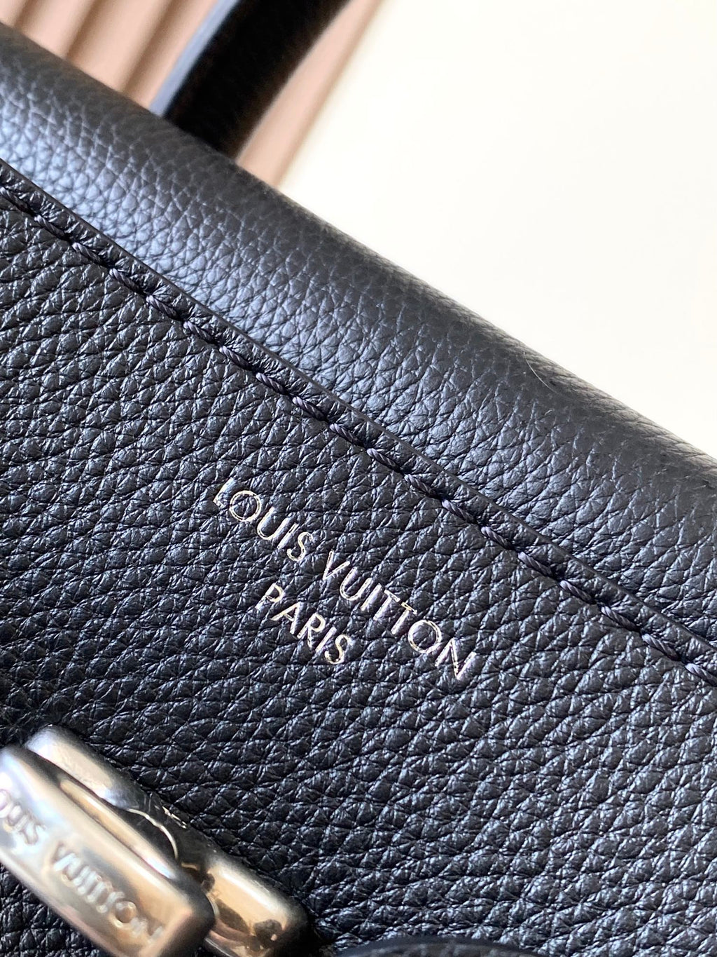 Louis Vuitton black leather handbag with “Louis Vuitton Paris” embossed text