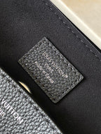 Louis Vuitton bag with leather monogram label and stitching detail, dark textured finish