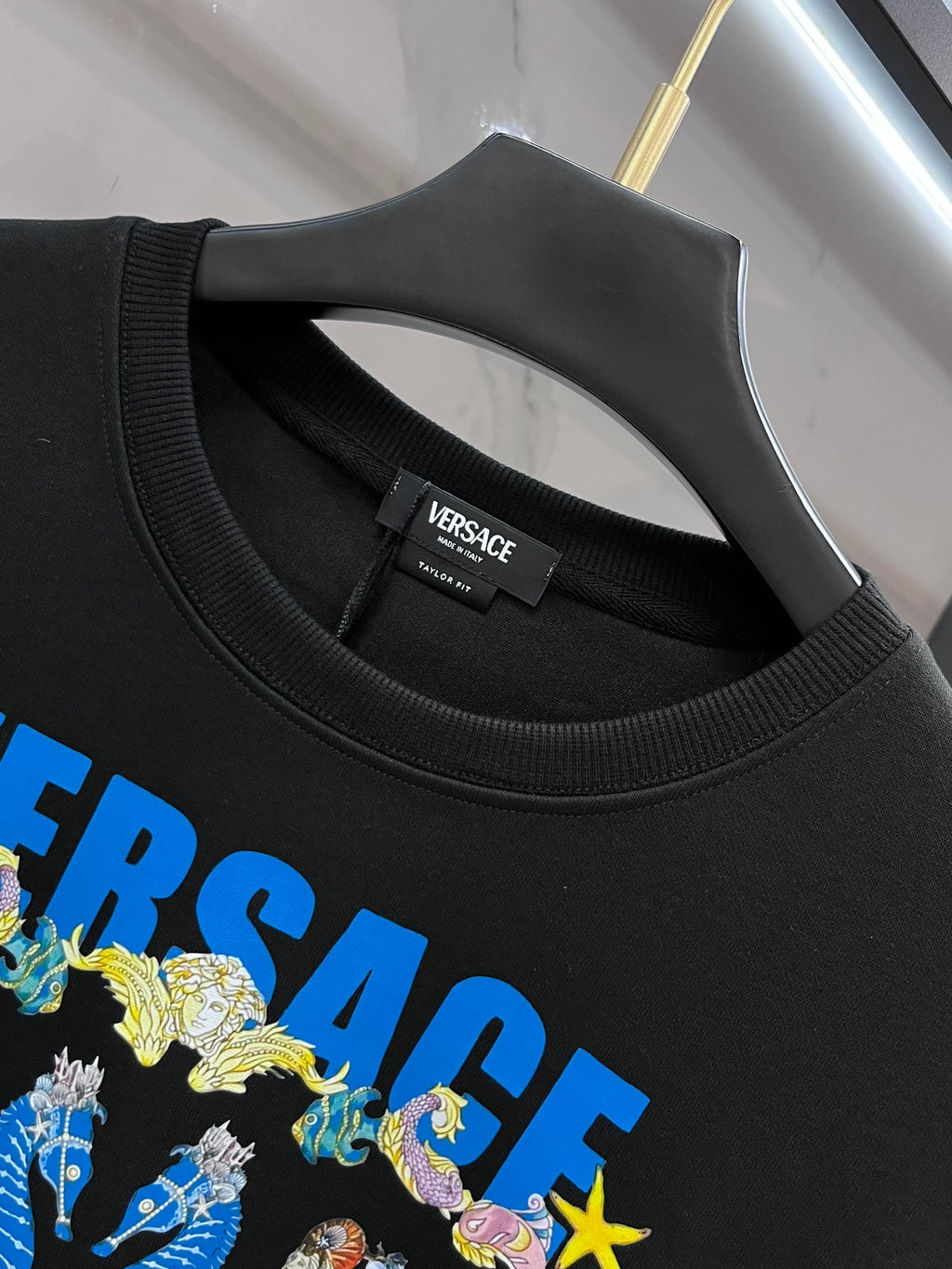 Black crewneck sweatshirt neckline with ribbed collar and multicolor logo graphic