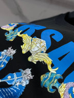 Black sweatshirt fabric detail with colorful fantasy figures and blue star-like shapes