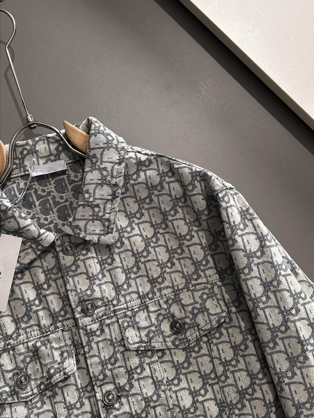 Long-sleeve logo-print jacket close-up at chest pocket and button placket