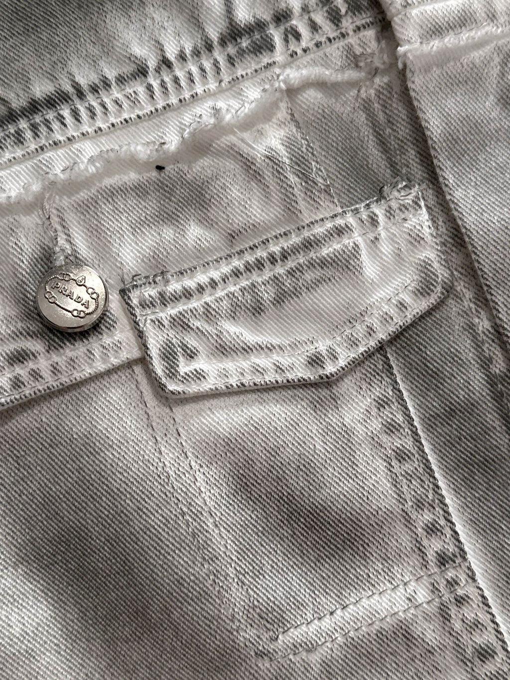 Light denim dress close-up of front pocket with stitched heart and button tab