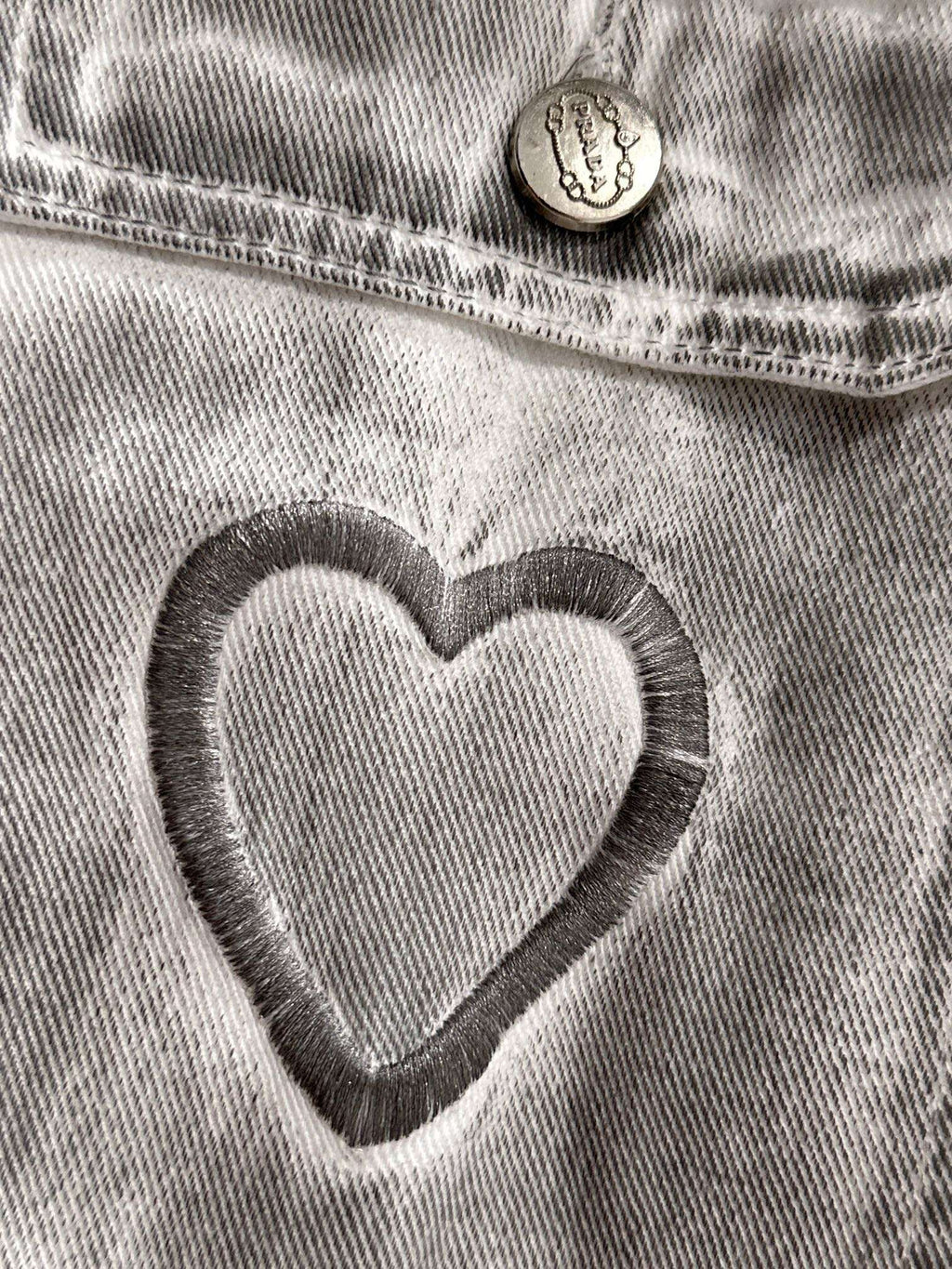 Light denim dress close-up of heart applique on chest pocket with round button