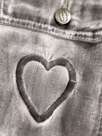 Light denim dress close-up of heart applique on chest pocket with round button